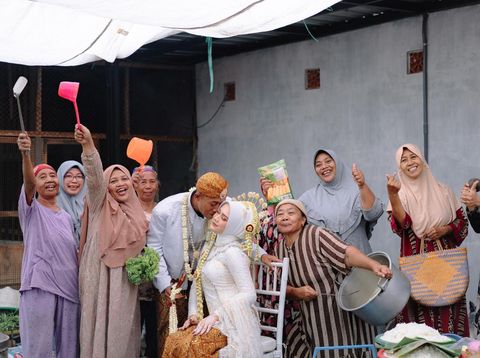 Foto pasangan Andy dan Yunda yang mengabadikan momen bersama ibu-ibu yang bertugas di dapur Foto pasangan Andy dan Yunda yang mengabadikan momen bersama ibu-ibu yang bertugas di dapur dan berjasa di hari pernikahannya. Unggahan tersebut langsung viral di media sosial
