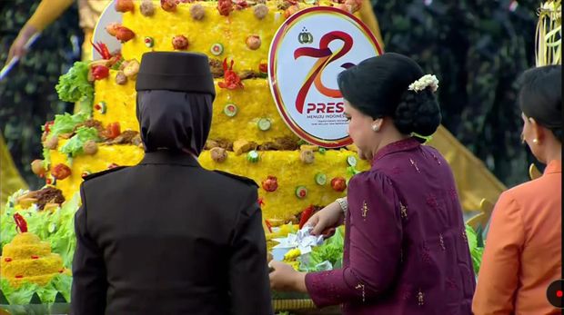 Ibu Negara Iriana Jokowi memotongkan dan menyerahkan tumpeng untuk Peraih Hoegeng Awards 2023 Kategori Pelindung Perempuan dan Anak (PPA), Kompol Yuni Utami.