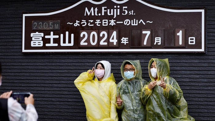 Visitors pose for a photo on the first day of climbing season at Fuji Yoshidaguchi Trail (Yoshida Route) at the fifth station of the slopes of Mount Fuji, in Fujiyoshida, Yamanashi Prefecture, Japan July 1, 2024. REUTERS/Issei Kato