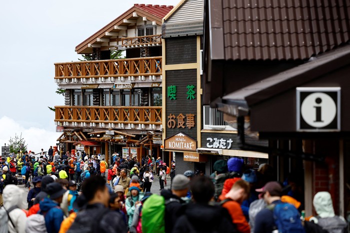 Visitors pose for a photo on the first day of climbing season at Fuji Yoshidaguchi Trail (Yoshida Route) at the fifth station of the slopes of Mount Fuji, in Fujiyoshida, Yamanashi Prefecture, Japan July 1, 2024. REUTERS/Issei Kato