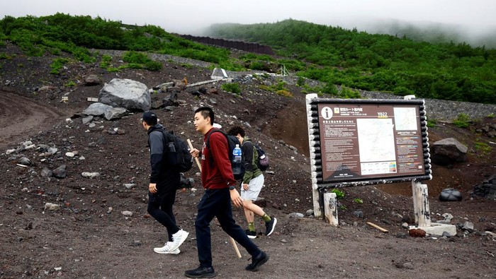 Visitors pose for a photo on the first day of climbing season at Fuji Yoshidaguchi Trail (Yoshida Route) at the fifth station of the slopes of Mount Fuji, in Fujiyoshida, Yamanashi Prefecture, Japan July 1, 2024. REUTERS/Issei Kato