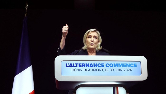 Kubu Macron Tumbang di Putaran Pertama Pemilihan Parlemen Prancis Supporters of Marine Le Pen, French far-right leader and far-right Rassemblement National (National Rally - RN) party candidate, celebrate after partial results in the first round of the early French parliamentary elections, in Henin-Beaumont, France, June 30, 2024. REUTERS/Yves Herman