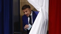 Presiden Prancis Emmanuel Macron meninggalkan bilik suara, saat ia mengunjungi tempat pemungutan suara untuk memberikan suara pada putaran pertama pemilihan awal parlemen Prancis, di Le Touquet-Paris-Plage, Prancis, Minggu (30/6/2024). REUTERS/Yara Nardi.  