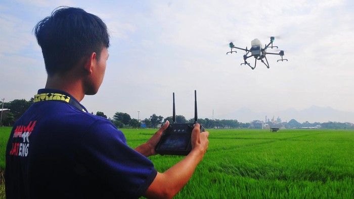 Petani Semprotkan Pestisida Pakai Drone, Begini Potretnya Pesawat drone terbang menyemprotkan pestisida di lahan pertanian Kelurahan Mlati Norowito, Kota, Kudus, Jawa Tengah, Senin (1/7/2024). Sejumlah petani di wilayah itu mulai beralih menggunakan jasa penyemprotan pestisida dengan teknologi drone yang dinilai lebih efisien untuk menekan biaya produksi dibandingkan cara konvensional, yaitu dengan tarif Rp250 ribu per hektar. ANTARA FOTO/Yusuf Nugroho/rwa.