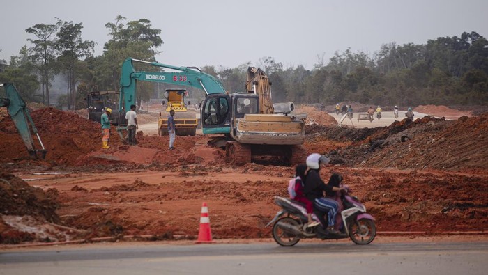 Potret Pengembangan Jalan Penghubung Kawasan Industri dan Wisata di Batam Pengendara sepeda motor melintas di dekat proyek pengembangan jalan penghubung kawasan KEK, pariwisata dan industri di Batam, Kepulauan Riau, Senin (24/6/2024). Pemerintah daerah setempat mengerjakan sebanyak 22 proyek pembangunan infrastruktur jalan pada 2024 guna mendukung kegiatan investasi dan kunjungan wisatawan asing diantaranya pengembangan jalan sepanjang 3,4 kilometer yang menghubungkan kawasan KEK Nongsa Digital Park, pariwisata Nongsa dan kawasan industri Kabil. ANTARA FOTO/Teguh Prihatna/YU