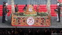Jokowi memotong tumpeng pada acara Hari Ulang Tahun (HUT) ke-78 Polri. Jokowi memberikan potongan tumpeng pertama kepada Kapolri Jenderal Listyo Sigit Prabowo.