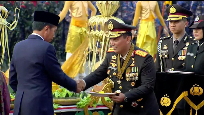 Presiden Jokowi memberikan potongan tumpeng kepada Kapolri Jenderal Listyo Sigit Prabowo.