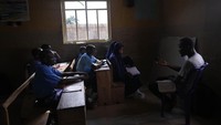 Siswa mengikuti pelajaran di ruang kelas yang remang-remang di Sekolah Excellent Moral, Ibadan, Nigeria.