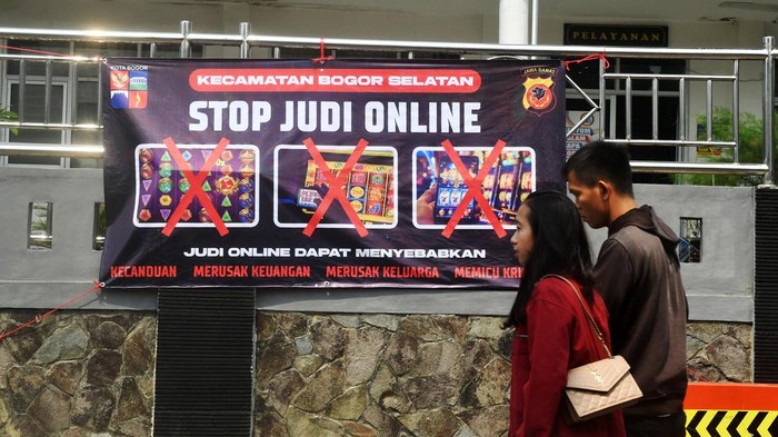 Warga berjalan di depan spanduk sosialisasi larangan judi online di Kantor Kecamatan Bogor Selatan, Kota Bogor, Jawa Barat, Senin (1/7/2024). Spanduk tersebut dipasang di sejumlah titik jalan dan kelurahan di wilayah Kecamatan Bogor Selatan karena berdasarkan data Pusat Pelaporan dan Analisis Transaksi Keuangan (PPATK) menyebutkan bahwa di kecamatan tersebut tercatat menjadi wilayah dengan nilai total transaksi judi online paling tinggi di Indonesia dengan pelaku judi online mencapai 3.720 orang dan perputaran uang sebanyak Rp349 miliar. ANTARA FOTO/Arif Firmansyah/YU