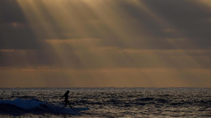 A surfer catches a wave at Cardiff State Beach in Encinitas, California, U.S., July 1, 2024.  REUTERS/Mike Bake