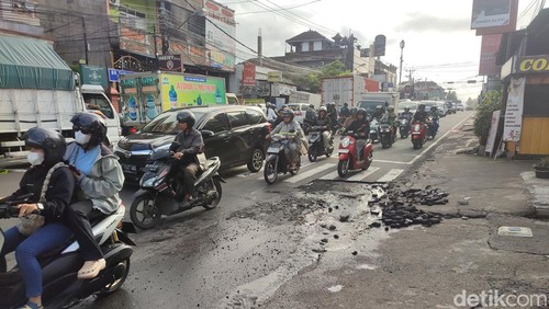 Kondisi Jalan Ahmad Yani di Tabanan yang rusak dan becek karena pipa bocor, Selasa (2/7/2024).