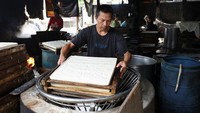 Perajin membawa tahu yang sudah jadi dan belum dipotong.