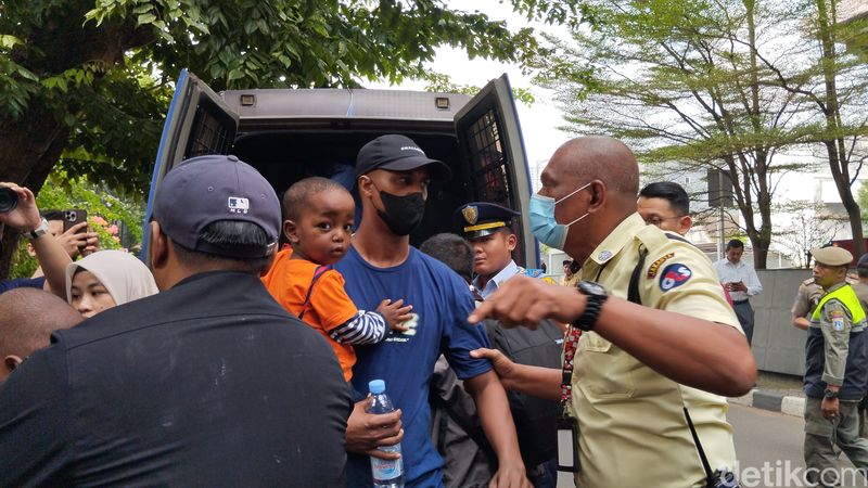 Para pencari suaka dari luar negeri melihat tenda-tendanya digusur Satpol PP, di belakang kantor UNHCR Indonesia, Jaksel, 2 Juli 2024. (Maulana Ilhami Fawdi/detikcom)
