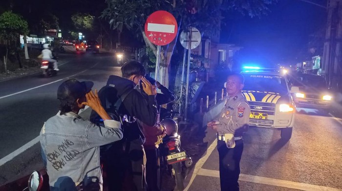 Pemotor lawan arah dihukum hormat ke arah rambu setop di Kota Batu.