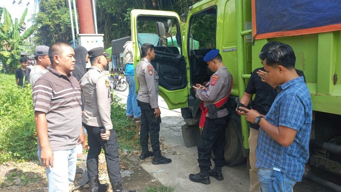 Polisi saat hendak mengevakuasi jasad korban yang ditemukan di dalam kabin truk. (Dok. Polresta Padang)
