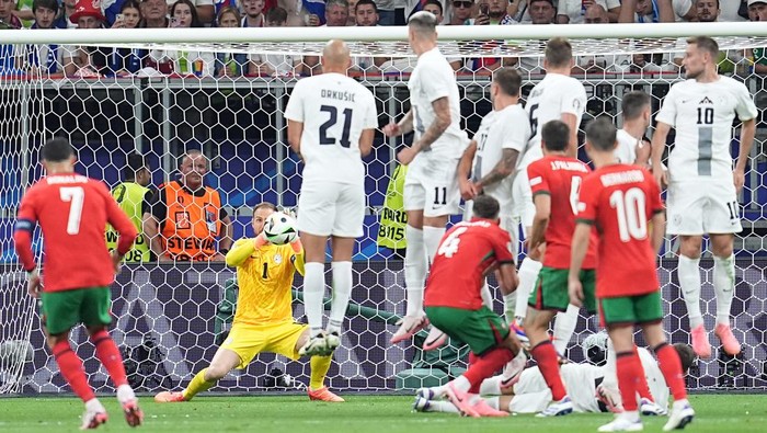01 July 2024, Hesse, Frankfurt/Main: Soccer: European Championship, Portugal - Slovenia, final round, round of 16, Frankfurt Arena, Portugals Cristiano Ronaldo (l) shoots a free kick, but Slovenias goalkeeper Jan Oblak (M) saves it. Photo: Uwe Anspach/dpa (Photo by Uwe Anspach/picture alliance via Getty Images)