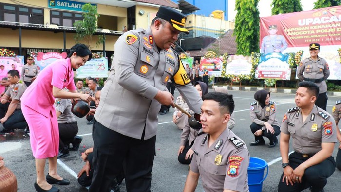 Puluhan anggota polisi dan PNS Polri di Polres Pelabuhan Tanjung Perak Surabaya mandi kembang usai naik pangkat.