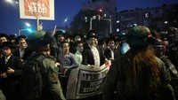 Sejumlah laki-laki Yahudi ultra-Ortodoks berunjuk rasa di Yerusalem pada hari Minggu (30/6) setelah Mahkamah Agung Israel memutuskan dengan suara bulat bahwa militer harus mulai merekrut mereka untuk wajib militer. (REUTERS/Ronen Zvulun)