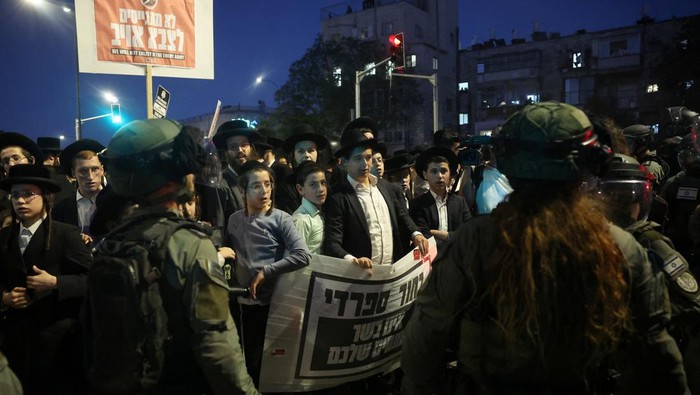 Yahudi Ultra-Ortodoks Marah Dipaksa Zionis Israel Ikut Wajib Militer Security forces operate as Ultra-Orthodox Jewish men protest an Israeli Supreme Court ruling that requires the state to begin drafting ultra-Orthodox Jewish seminary students to the military, in the Mea Shearim neighbourhood of Jerusalem, June 30, 2024. REUTERS/Ronen Zvulun
