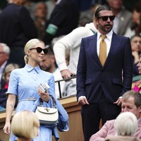 Istri Dave juga bergaya preppy. Jordyn mamakai setelan serba biru dipadu rok senada dan tas klasik Gucci. (Foto: Mike Egerton/PA via AP)