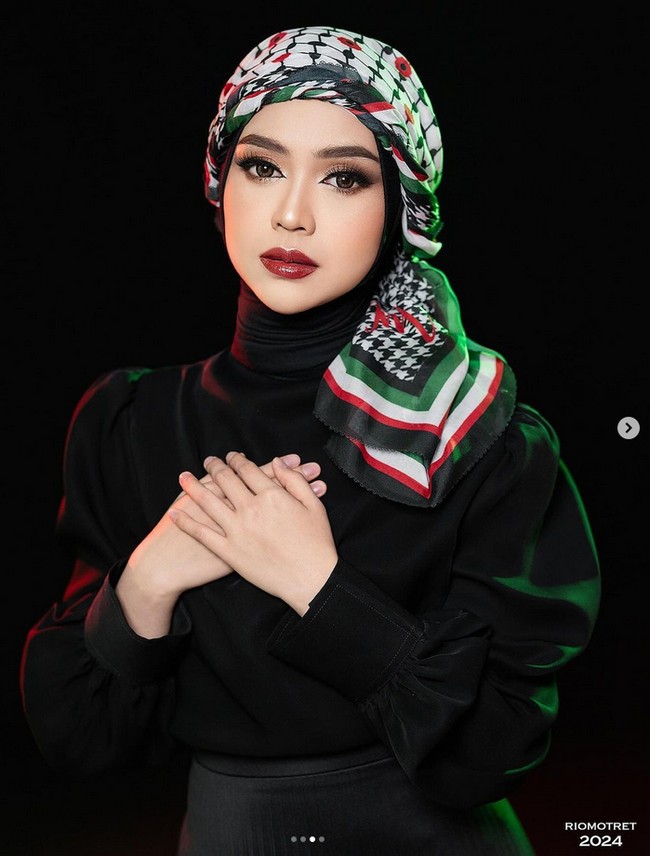 Ria Ricis menunaikan ibadah haji pada tahun ini, bersama dua kakaknya Oki Setiana Dewi dan Shindy Putri. Wanita kelahiran 1 Juli 1995 ini menggunakan hijab warna hitam dan diikat melilit di leher. Lapisan luar, Ria Ricis membentuk keffiyeh motif Palestina seperti model turban dari brand hijab @mazuscarf milik Marini Zumarnis. Foto: Dok. Instagram @riomotret.