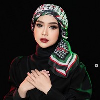 Ria Ricis menunaikan ibadah haji pada tahun ini, bersama dua kakaknya Oki Setiana Dewi dan Shindy Putri. Wanita kelahiran 1 Juli 1995 ini menggunakan hijab warna hitam dan diikat melilit di leher. Lapisan luar, Ria Ricis membentuk keffiyeh motif Palestina seperti model turban dari brand hijab @mazuscarf milik Marini Zumarnis. Foto: Dok. Instagram @riomotret.