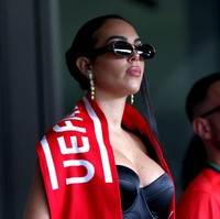 Georgina melepas jaket kulitnya dan menutupi bahunya dengan scarf merah Portugal. Foto: Getty Images/Kevin C. Cox