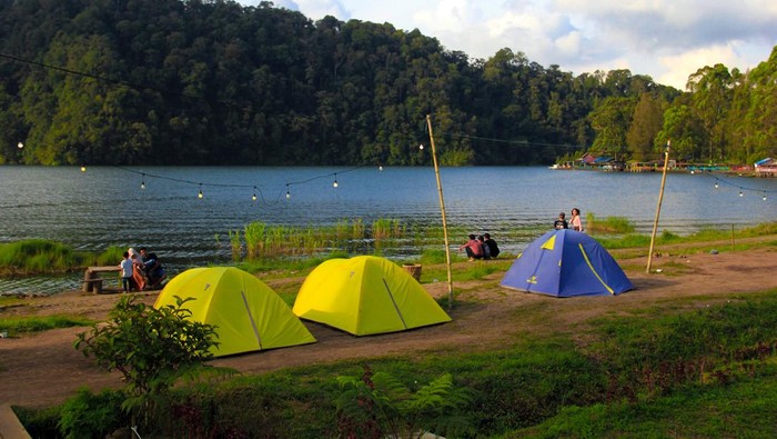 Sejumlah pengunjung menikmati keindahan Danau Law Kawar di Desa Kutagugung, Kecamatan Naman Teran, Kabupaten Karo, Sumatera Utara, Rabu (3/7/2024). Wisata Danau Law Kawar yang memiliki luas 200 hektare tersebut merupakan wisata legenda yang menceritakan sebuah desa yang tenggelam akibat kutukan seorang nenek yang merasa sakit hati kepada anak dan cucu yang telah memberikan makan sisa dari acara adat masyarakat Karo. ANTARA FOTO/Yudi Manar/foc.