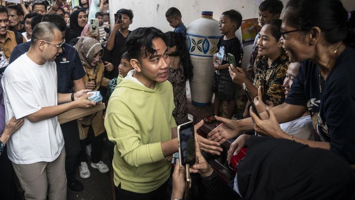 Momen Gibran Blusukan di Jakarta, Ditemani Raffi Ahmad Bagikan Susu dan Buku Wakil Presiden Terpilih Gibran Rakabuming Raka (kanan) didampingi artis Rafi Ahmad (kiri) menyalami warga saat blusukan di Gang I Kelurahan Pasar Manggis, Jakarta, Rabu (3/7/2024). Dalam kesempatan tersebut, putra sulung Presiden Joko Widodo itu membagikan buku dan susu gratis kepada anak-anak. ANTARA FOTO/Aprillio Akbar/Spt.