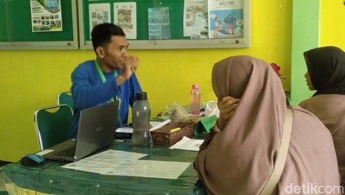 Panitia PPDB SMAN 10 Mataram tengah memberikan informasi kepada calon peserta didik, Rabu (3/7/2024). (Nathea Citra/detikBali)