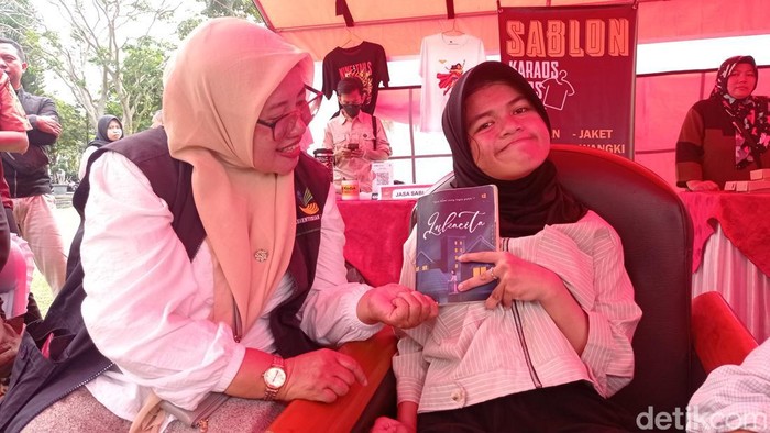 Penyintas cerebral palsy Sida Rohmatul Fadillah menunjukkan buku karyanya.