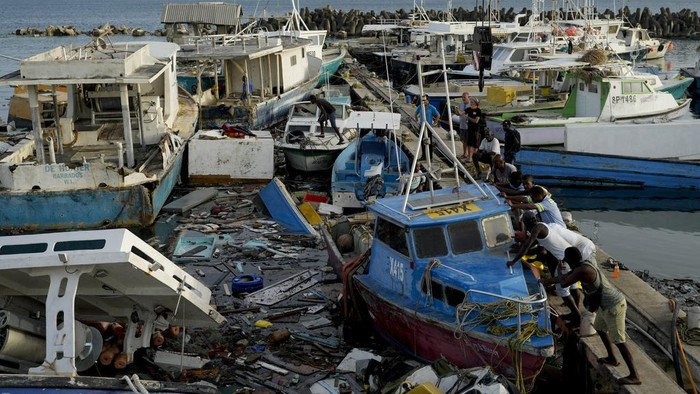 Fishermen push a boat damaged by Hurricane Beryl at the Bridgetown fisheries, Barbados, Tuesday, July 2, 2024. (AP Photo/Ricardo Mazalan)