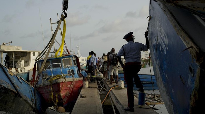 Puluhan Kapal Nelayan di Barbados Hancur Diterjang Badai Beryl Fishermen push a boat damaged by Hurricane Beryl at the Bridgetown fisheries, Barbados, Tuesday, July 2, 2024. (AP Photo/Ricardo Mazalan)