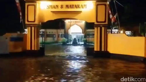 Sejumlah wilayah di Kota Mataram terendam air akibat hujan yang mengguyur sejak pagi hingga malam. Salah satunya di depan SMAN 8 Mataram, Jalan Dr Soedjono, Dasan Cermen, Sandubaya, Kota Mataram, Rabu (3/7/2024). (Foto: Nathea Citra/detikBali)