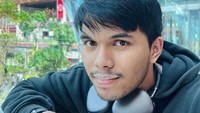 Ia senang menikmati kopi hangat di sela-sela waktu istirahatnya. Gayanya tampak santai, sambil mengenakan jaket dan headphone ia menyeruput kopi hangatnya. Foto: Instagram/thariqhalilintar