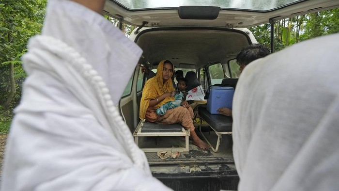 25-year-old Jahanara Khatoon, who is at full-term pregnancy, lies in pain with onset of labour as health officers hold a tarpaulin to give her cover, over the River Brahmaputra, in the northeastern Indian state of Assam, Wednesday, July 3, 2024. (AP Photo/Anupam Nath)
