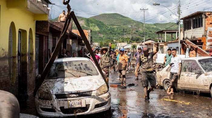 Mobil-mobil Ringsek Disapu Badai Beryl A man walks near damaged vehicles after devastating floods swept through the town after Hurricane Beryl passed off the Venezuelan coast, in Cumanacoa, Venezuela, July 2, 2024. REUTERS/Samir Aponte TPX IMAGES OF THE DAY