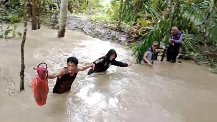 Petugas pantarlih menerobos derasnya sungai di Muna, Sultra.