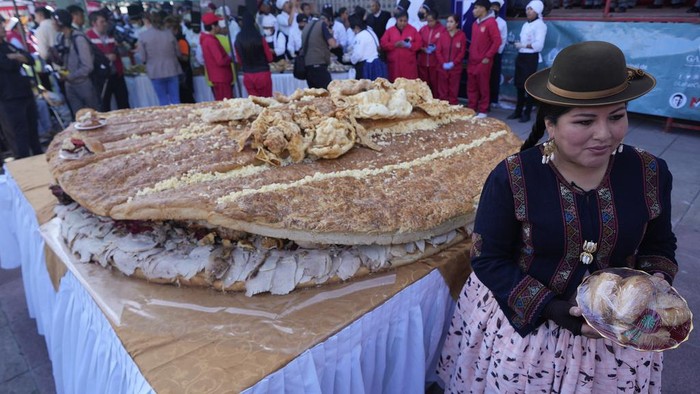 Potret Sandwich Raksasa Seberat 380 Kilogram di Bolivia Cholitas pose for a photo during the presentation of a giant