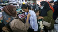 Dengan membawa putra-putrinya, mereka antusias meminta sang anak untuk menjajal seragam baru yang akan digunakan nanti.