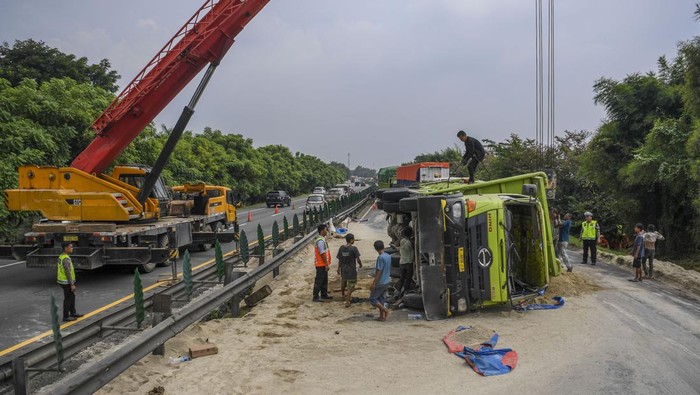 Potret Truk Bermuatan Pasir Kecelakaan di Tol Tangerang-Merak KM 75 Petugas melakukan evakuasi truk bermuatan pasir yang mengalami kecelakaan di Jalan Tol Tangerang-Merak KM 75, Serang Barat, Banten, Kamis (4/7/2024). Kecelakaan tunggal truk bernomor polisi A 9808 B itu menyebabkan arus lalu lintas di jalan tol yang mengarah ke Jakarta mengalami kemacetan panjang. ANTARA FOTO/Galih Pradipta/tom.