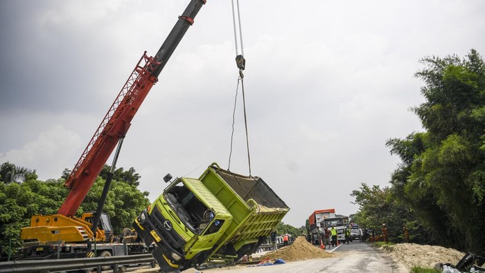 Petugas melakukan evakuasi truk bermuatan pasir yang mengalami kecelakaan di Jalan Tol Tangerang-Merak KM 75, Serang Barat, Banten, Kamis (4/7/2024). Kecelakaan tunggal truk bernomor polisi A 9808 B itu menyebabkan arus lalu lintas di jalan tol yang mengarah ke Jakarta mengalami kemacetan panjang. ANTARA FOTO/Galih Pradipta/tom.