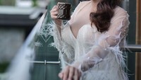 Minum kopi di balkon menjadi gayanya untuk membangkitkan energi di pagi hari. Tentunya dengan pakaian putih yang cantik dan glamour. Foto: Instagram/ayuaulia