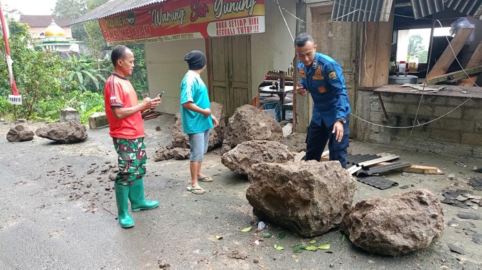 Material longsor batu yang menimpa sebuah warung di Trenggalek.