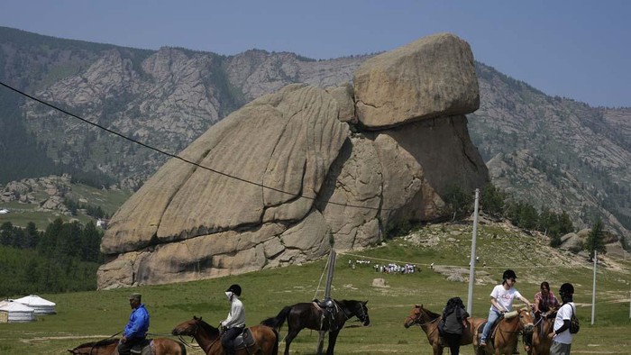 Melihat Turtle Rock, Batu Menyerupai Kura-kura di Mongolia Tourists get off the bus near the iconic Turtle Rock at the Terejl National Park outside Ulaanbaatar, Mongolia, Wednesday, July 3, 2024. (AP Photo/Ng Han Guan)