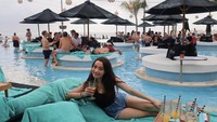 Santai di beach club Bali, Megan Domani menikmati pemandangan kolam renang dan pantai. Tak lupa ia ditemani ragam minuman segar. Foto: Instagram megandomani1410