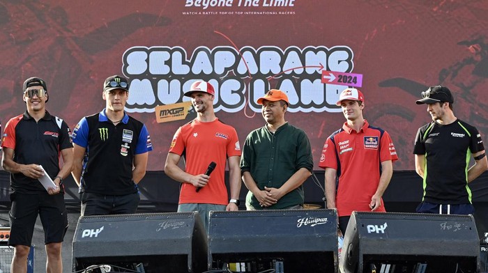 Pembalap Team HRC Tim Gajser (kiri) membagikan poster yang bergambar dirinya kepada warga saat acara Meet and Greet pembalap MXGP di Sirkuit MXGP Selaparang, Mataram, NTB, Jumat (5/7/2024). Kegiatan tersebut untuk mengenalkan para pembalap dan ofisial MXGP dan MX2 kepada warga sebelum bertanding pada race seri ke-12 MXGP Lombok 6-7 Juli 2024. ANTARA FOTO/Ahmad Subaidi/tom.