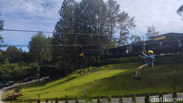 Menparekraf Sandiaga Uno melakukan aksi naik flying fox saat hadiri Apresiasi Kreasi Indonesia (AKI) di Kaldera Toba.