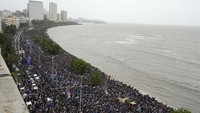 Kerumunan menunggu di sepanjang Marine Drive hingga tim kriket India tiba di Mumbai, India, Kamis (4/7/2024).  