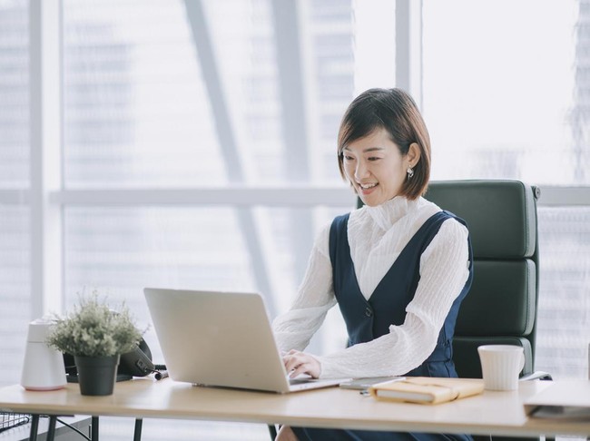 1299703465 asian chinese beautiful female manager working using her laptop typing in the office